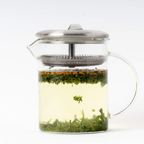 Glass brewer with brewed Organic Genmaicha inside. Organic Genmaicha is a green tea from True Tea, a tea company based in Portland, Oregon