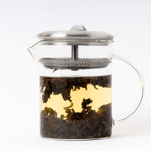 Glass brewer with brewed Organic  Dong Ding tea inside. Organic  Dong Ding is a rare loose leaf tea from True Tea, a tea company based in Portland, Oregon