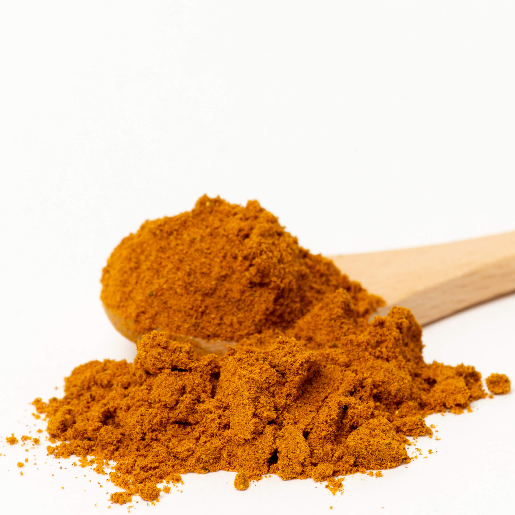 Orange powder with a wooden spoon. The powder is Golden Milk, a tea from True Tea based in Portland, Oregon